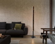 Moderne LED-Stehleuchte in einem gemütlichen Wohnzimmer, seitliche Perspektive