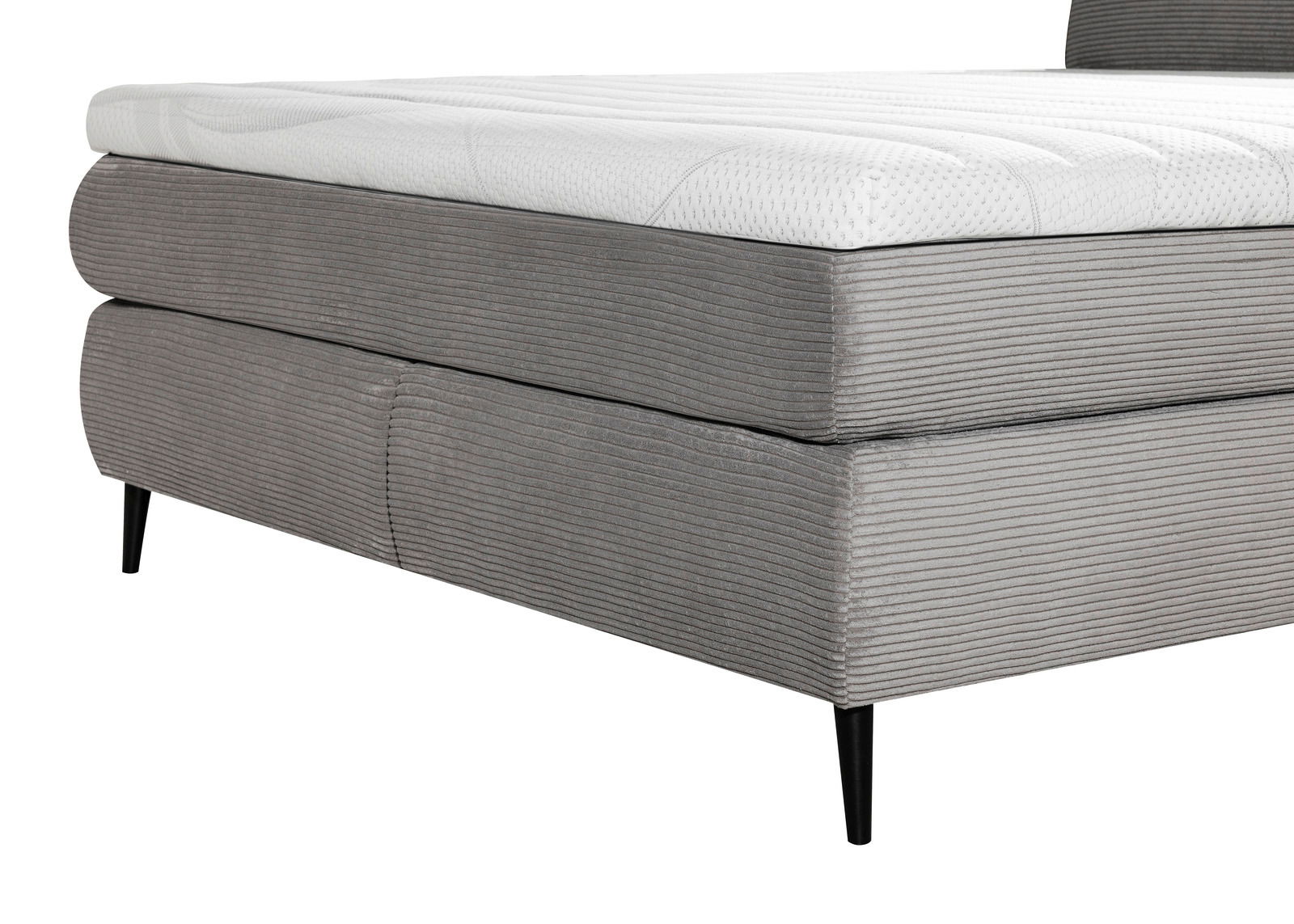 Nahaufnahme eines grauen Boxspringbetts mit gestepptem Stoffbezug und schwarzen Beinen, seitliche Perspektive