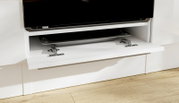 Weiße TV-Wohnwand mit nach unten geöffneter Klappe und sichtbaren Metall-Scharnieren, Detailansicht aus frontaler leicht schräger Perspektive