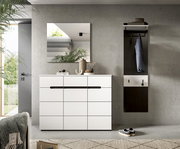 Modernes Flur-Set mit weißer Kommode und schwarzer Griffleiste, quadratischem Wandspiegel darüber sowie Garderobenpaneel mit Ablage und Haken; frontale Perspektive.