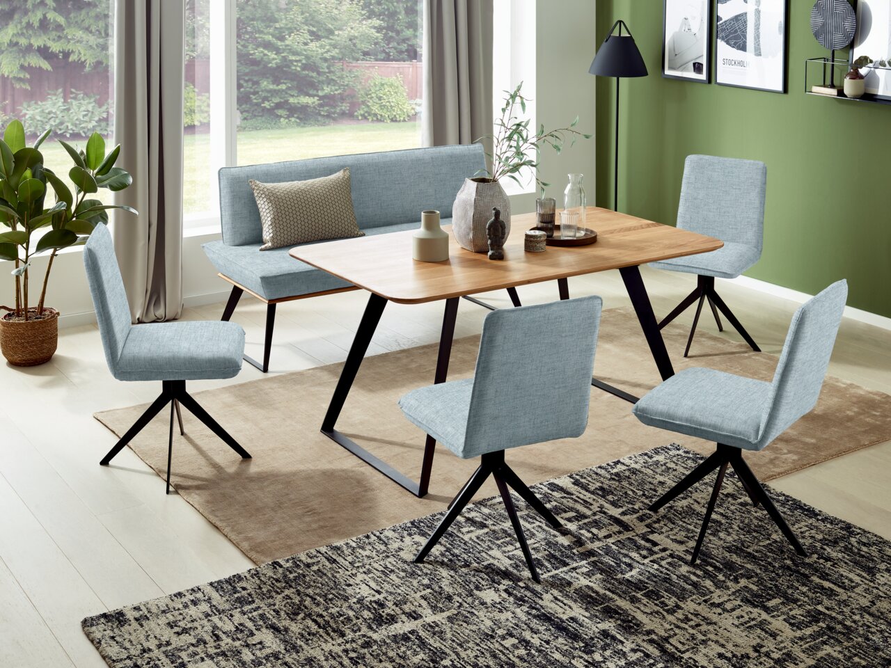 Eetkamer met een moderne tafel en vier lichtblauwe stoelen, zijaanzicht