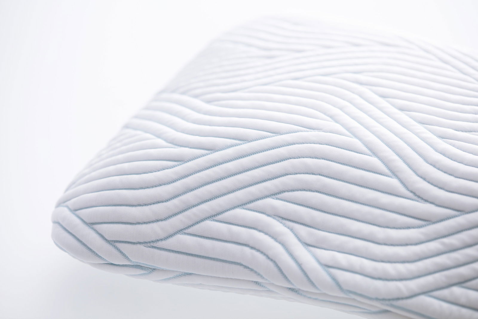 Nahaufnahme eines Schlafkissens mit wellenförmigem Muster, perspektivisch von der Seite aufgenommen.