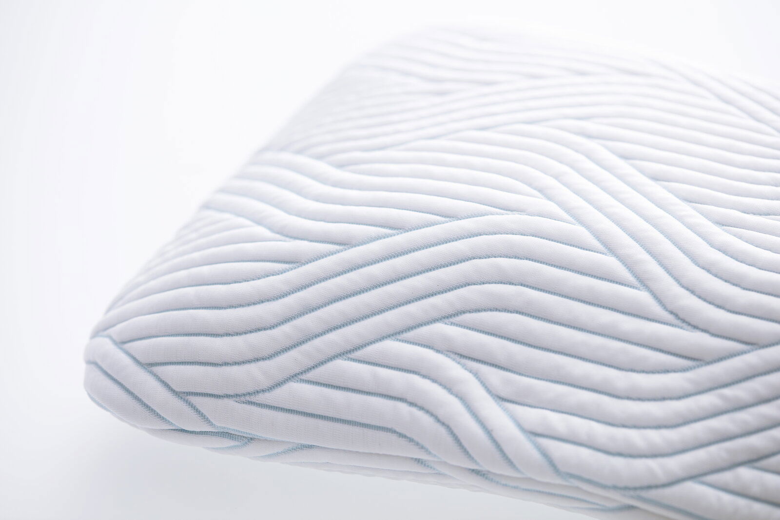 Nahaufnahme eines Schlafkissens mit wellenförmigem Muster, perspektivisch von der Seite aufgenommen.