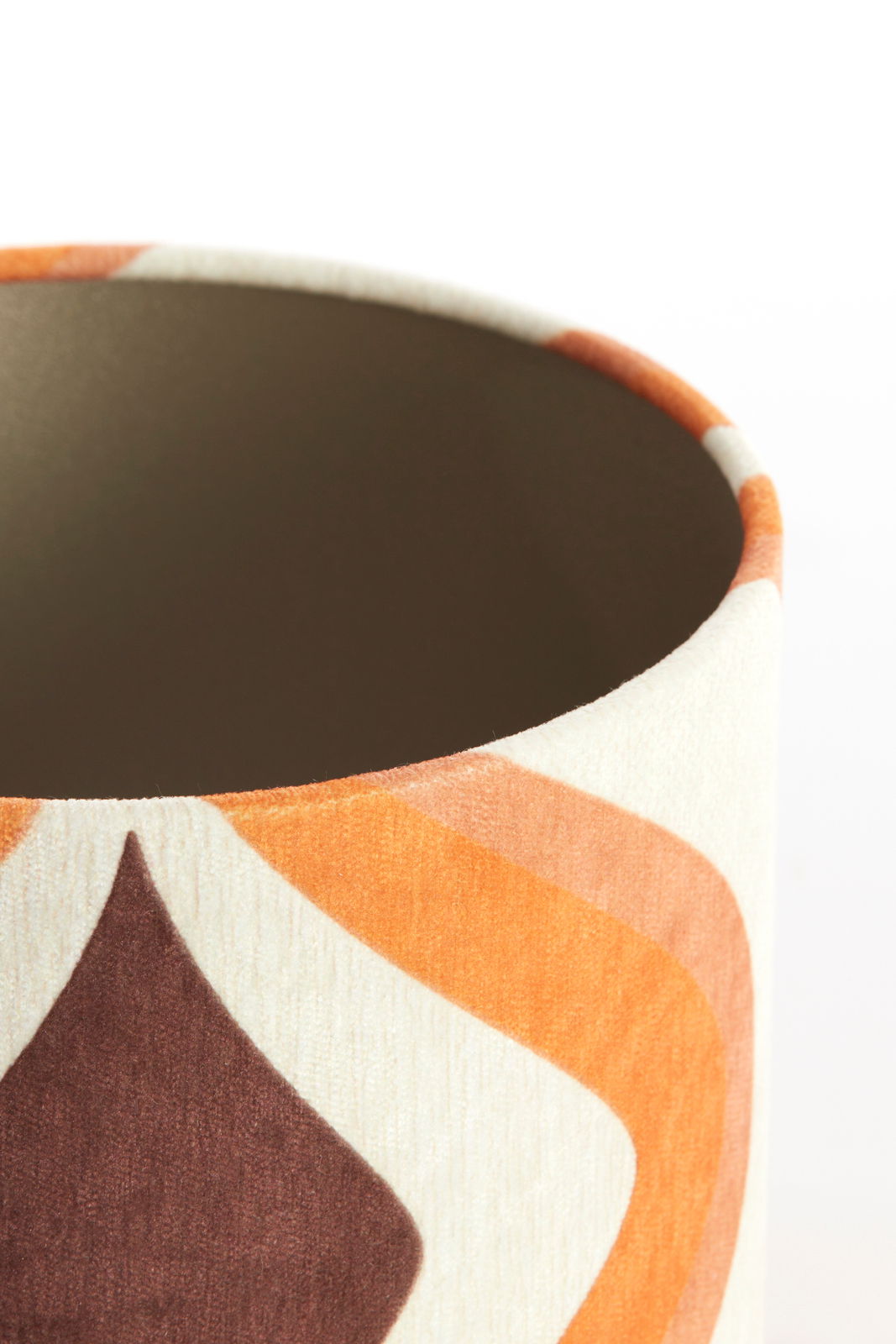 Nahaufnahme eines Lampenschirms mit geometrischem Muster in Braun- und Orangetönen, von oben betrachtet.