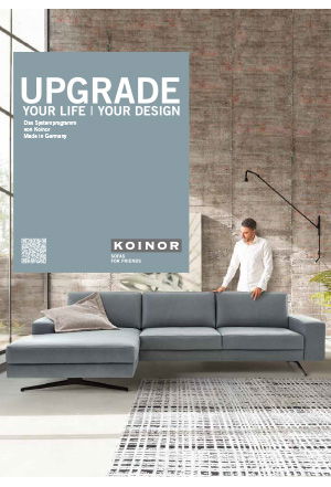 Graues Sofa vor einer Backsteinwand in einem hellen Raum.