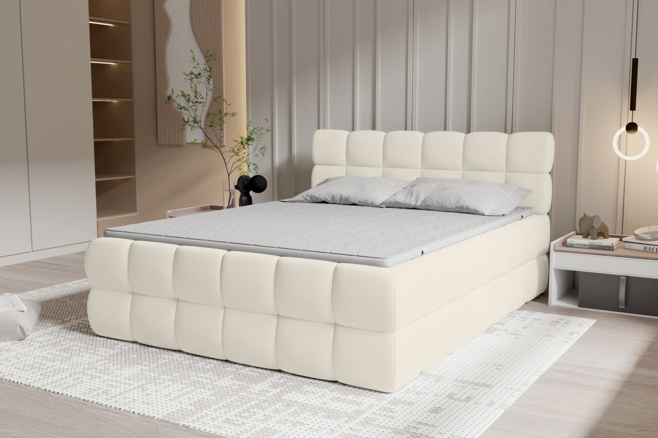 Modernes, gepolstertes Polsterbett in Cremeweiß mit quadratisch gestepptem Kopfteil und Bettrahmen, Matratze und zwei grauen Kissen im hellen Schlafzimmer, Perspektive: frontale 3/4-Ansicht von links.