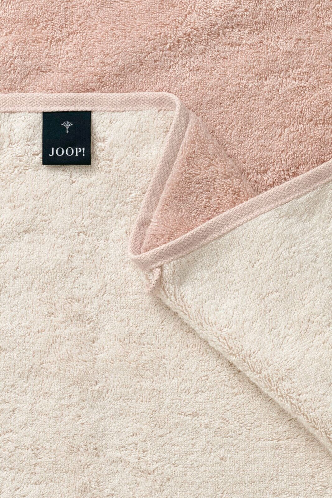 Nahaufnahme eines zweifarbigen Duschtuchs in Rosa und Creme mit einem Joop-Label, von oben betrachtet.