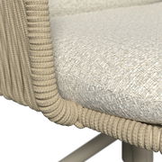 Detailaufnahme aus seitlicher Perspektive: gepolsterter Sitz mit hellbeigem, strukturiertem Stoffbezug und umlaufender, geflochtener Kordel-/Seilumrandung am Rahmen