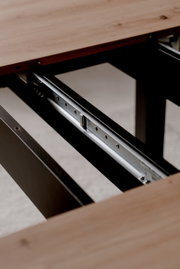 Nahaufnahme eines Esstisches mit ausziehbarer Metallführung, Perspektive von der Seite