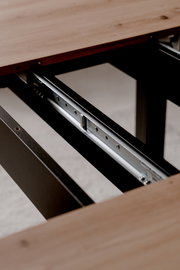 Nahaufnahme eines Esstisches mit ausziehbarer Metallführung, Perspektive von der Seite