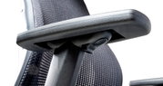 Nahaufnahme eines ergonomischen Drehstuhls mit Armlehne und Netzrückenlehne, seitliche Perspektive