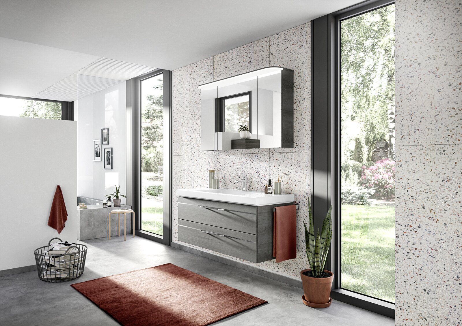 Moderner Badblock mit Spiegel und Waschbecken in einem hellen Badezimmer mit großen Fenstern, seitliche Perspektive.