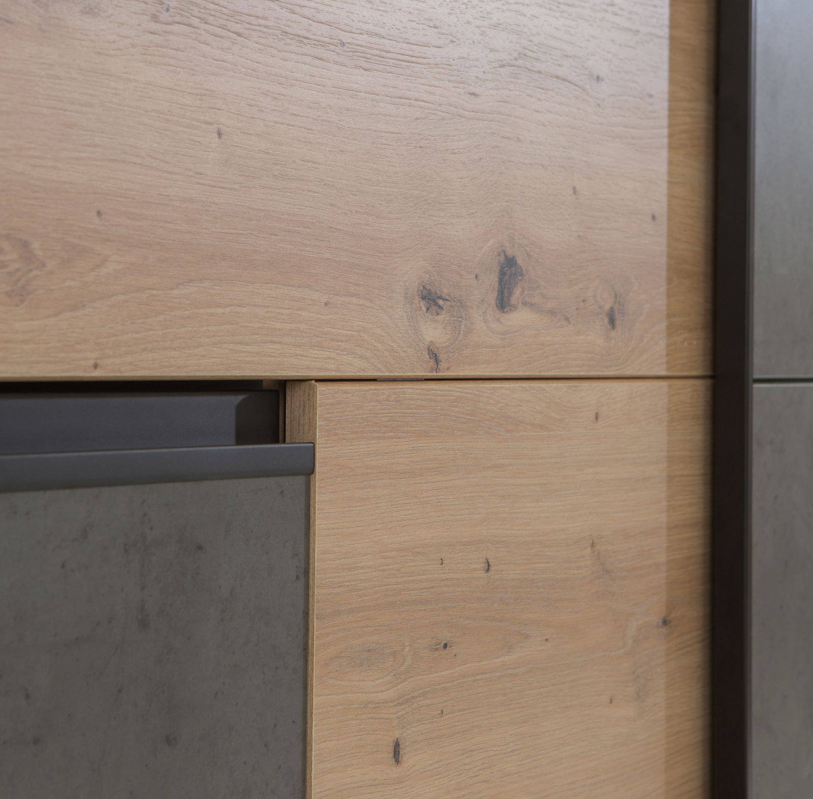 Nahaufnahme eines Schwebetürenschranks mit Holz- und Betonelementen, seitliche Perspektive.