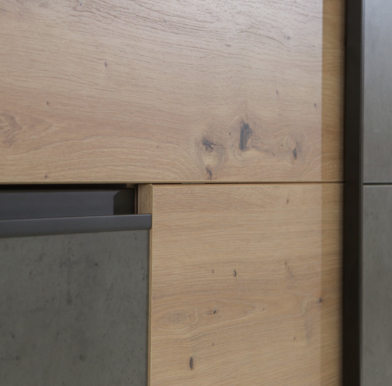 Nahaufnahme eines Schwebetürenschranks mit Holz- und Betonelementen, seitliche Perspektive.