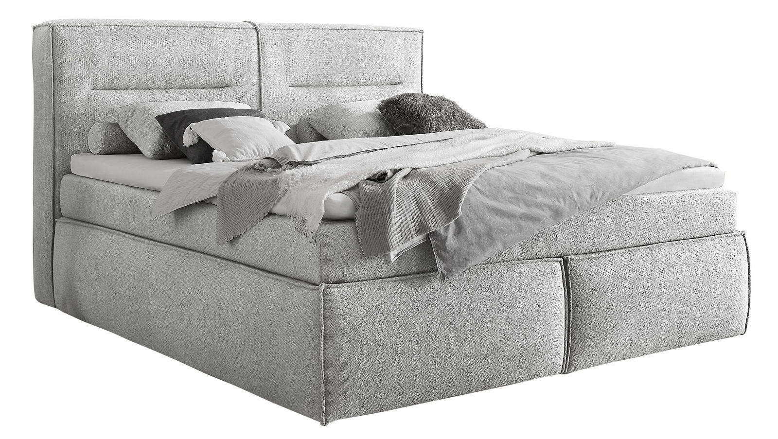 Boxspringbett in hellgrauem Stoff, seitliche Perspektive, mit Kissen und Decken dekoriert