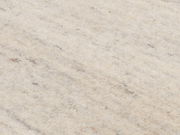 Nahaufnahme eines cremefarbenen Wollteppichs mit leichter Textur und dezenten Farbnuancen, von oben betrachtet.