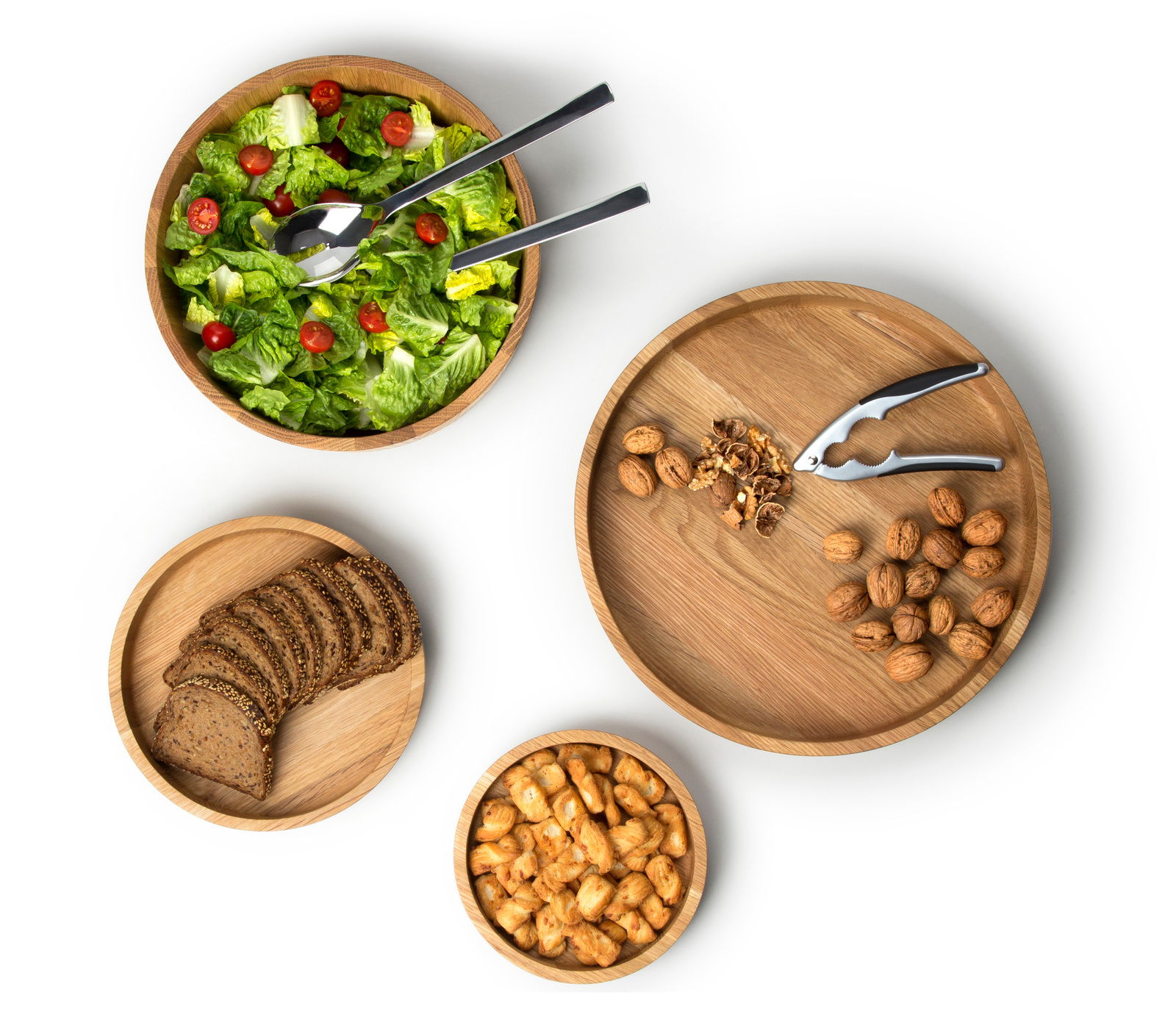 Continenta Schale Eiche Vogelperspektive auf vier Eichenholzschalen der Continenta Schüssel-Serie, gefüllt mit Salat, Brot, Nüssen und Snacks.