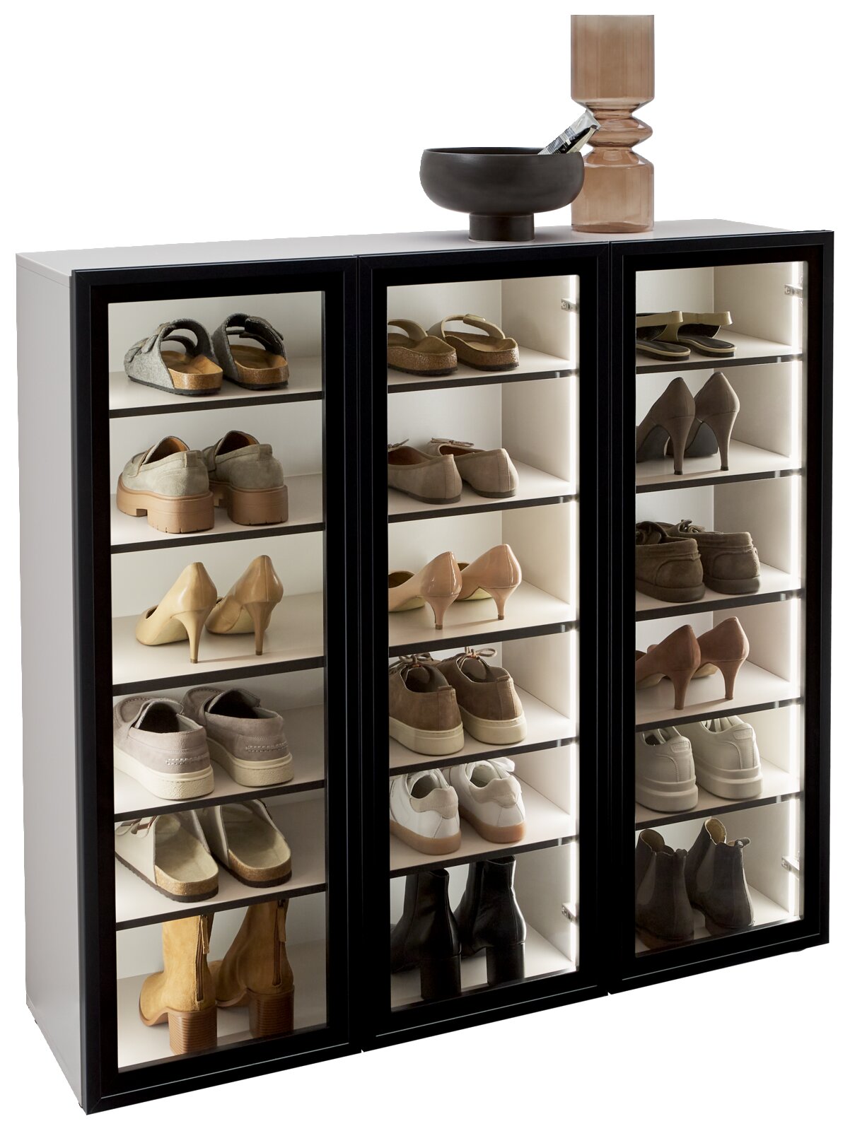 Voleo Schuhschrank-Vitrine KIARA Schuhschrank-Vitrine mit drei Glastüren, gefüllt mit verschiedenen Schuhen, aus seitlicher Perspektive fotografiert.