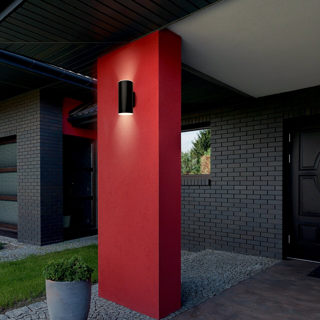 Moderne schwarze Akku-Außenwandleuchte an einer roten Wand, seitliche Perspektive