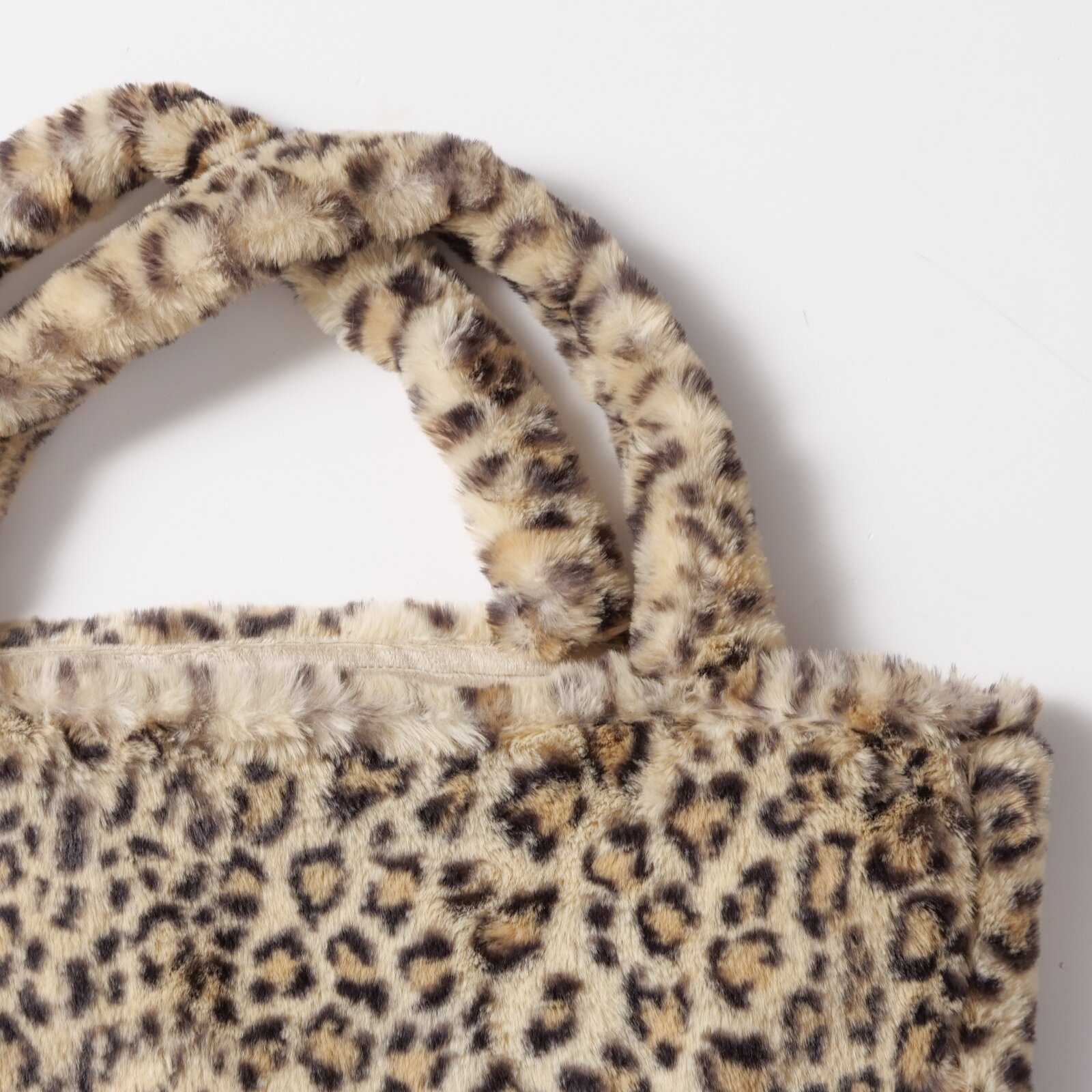 Close-up van een Leony-tas met luipaardprint en zacht, pluche materiaal, gezien van bovenaf.