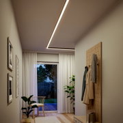 Moderne L-förmige LED-Deckenleuchte als Lichtlinie in einem Flur mit Garderobenwand und Fensterfront, Perspektive von unten nach oben in den Raum (Froschperspektive)