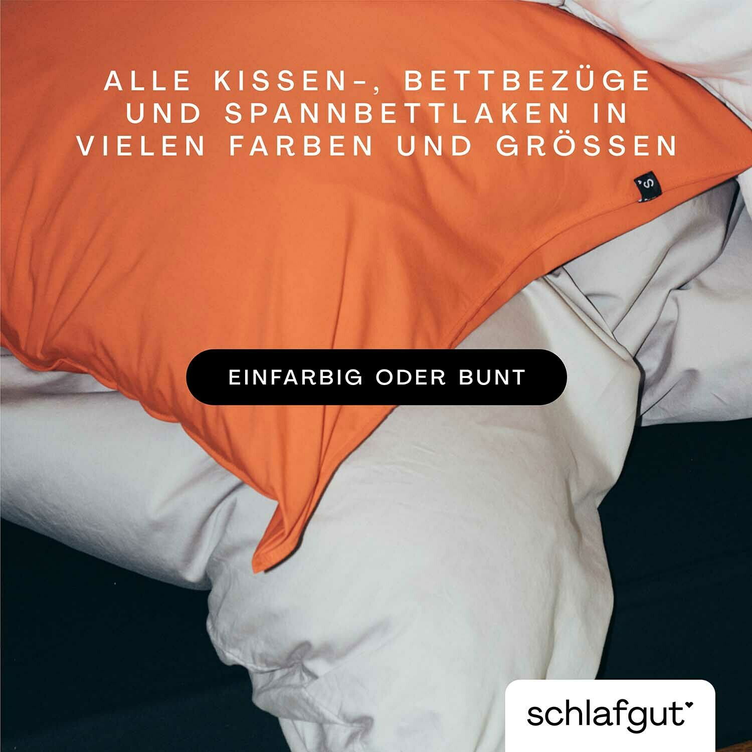 Nahaufnahme eines Bettes mit einem orangefarbenen Kissenbezug und weißen Bettlaken, die in verschiedenen Farben und Größen erhältlich sind.