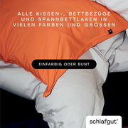 Nahaufnahme eines Bettes mit einem orangefarbenen Kissenbezug und weißen Bettlaken, die in verschiedenen Farben und Größen erhältlich sind.