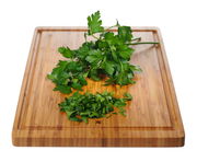 Bambus-Schneidbrett mit frischer Petersilie, aus der Vogelperspektive fotografiert.