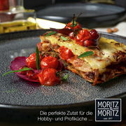 Nahaufnahme eines eleganten grauen Tellers mit einer Portion Lasagne, garniert mit frischen Tomaten und Kräutern, ideal für Hobby- und Profiköche.
