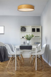 Moderne plafondlamp met houtlook in een stijlvolle eetkamer, gezien van onderaf.