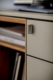 Nahaufnahme einer modernen Wandkombination mit grauen Schubladen und einem offenen Holzregal, seitliche Perspektive.