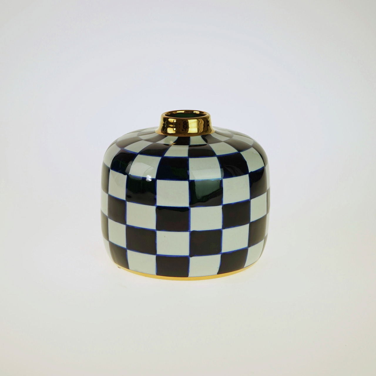 Handbemalte Vase Harlekin mit schwarz-weißem Karomuster und goldener Öffnung, frontal fotografiert.