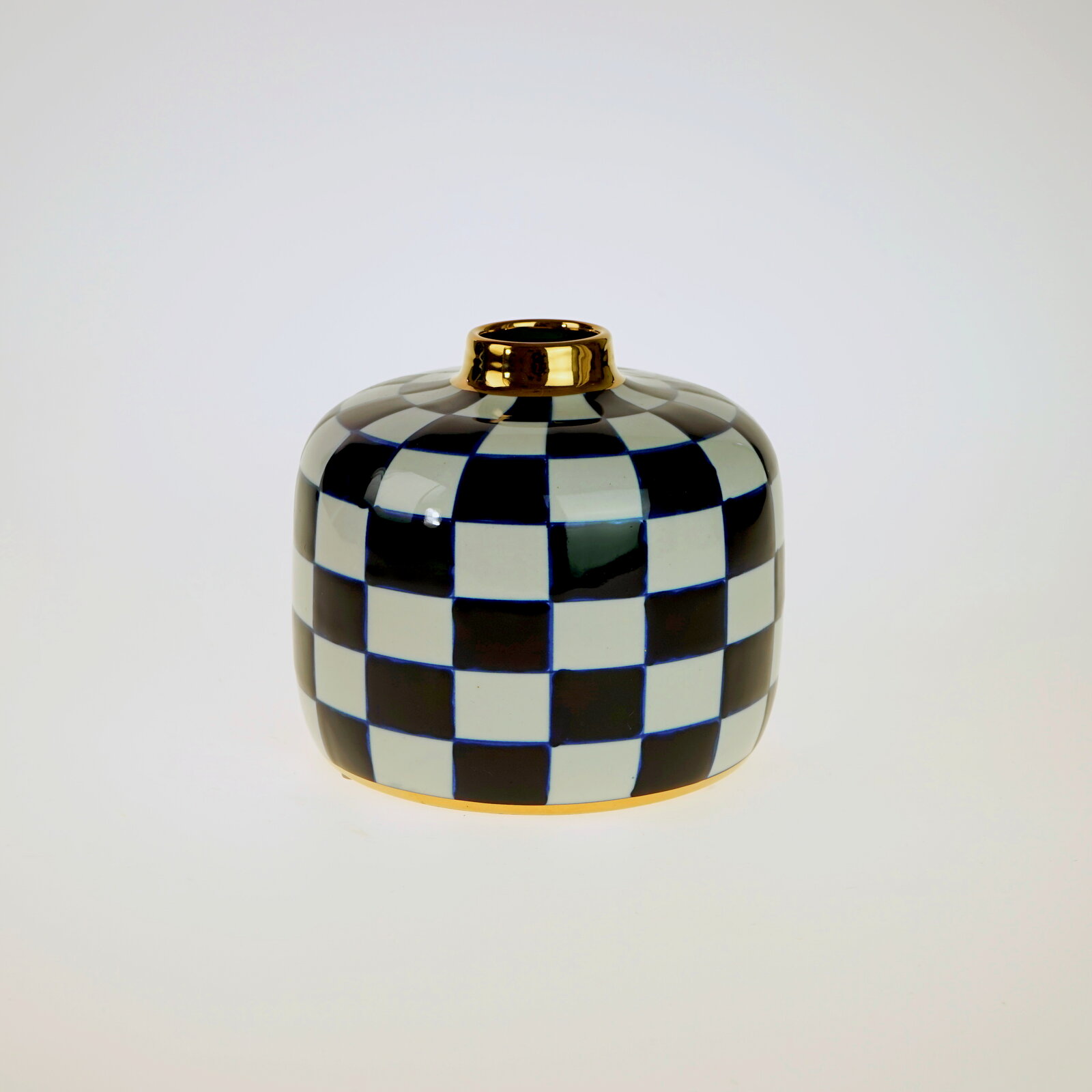 Handbemalte Vase Harlekin mit schwarz-weißem Karomuster und goldener Öffnung, frontal fotografiert.