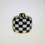 Handbemalte Vase Harlekin mit schwarz-weißem Karomuster und goldener Öffnung, frontal fotografiert.