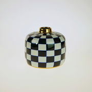 Handbemalte Vase Harlekin mit schwarz-weißem Karomuster und goldener Öffnung, frontal fotografiert.