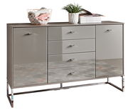 Moderne Kombikommode mit glänzender Oberfläche, zwei Türen und vier Schubladen, frontal abgebildet. Dekoriert mit einem Drahtkorb, Pflanzen und Büchern.