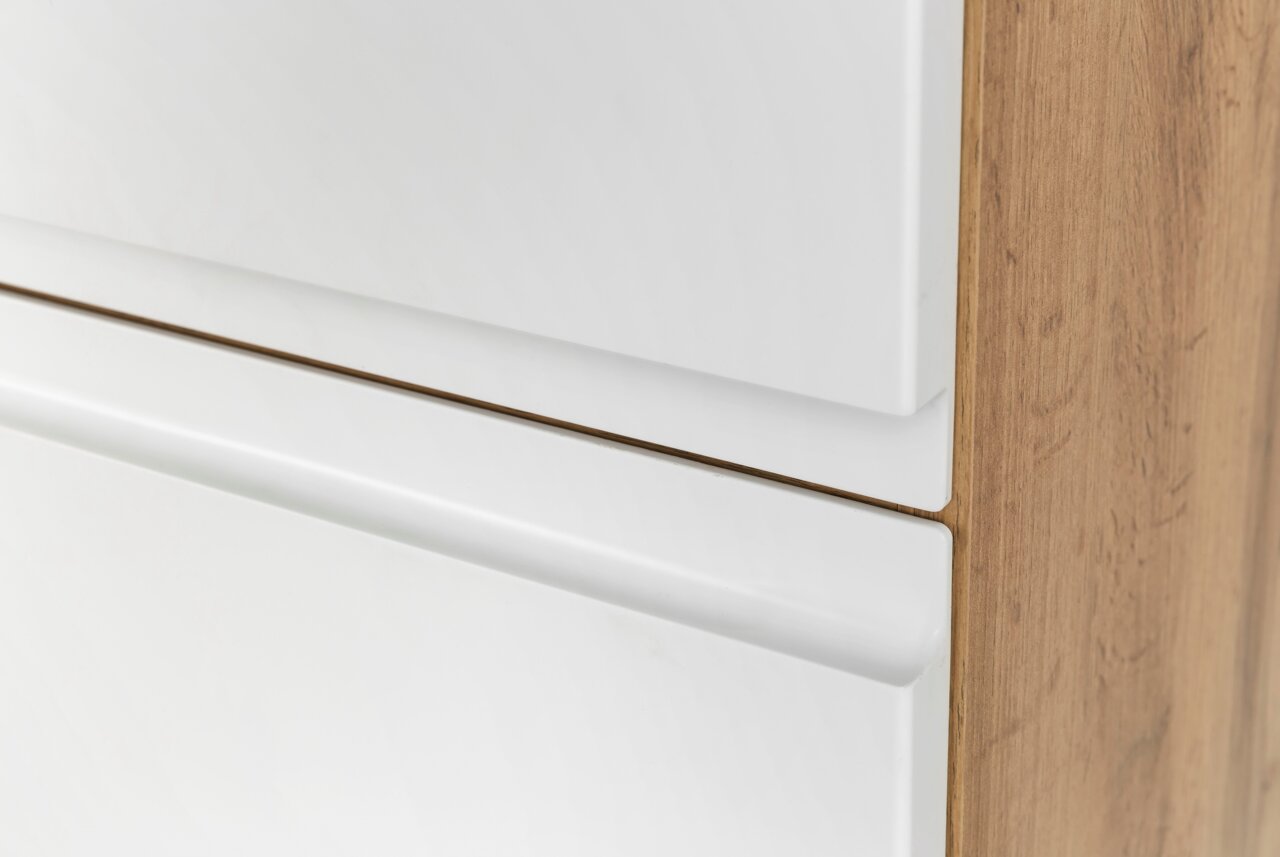 Nahaufnahme eines Hochschranks mit weißen Fronten und Holzseitenansicht, perspektivisch von der Seite aufgenommen.