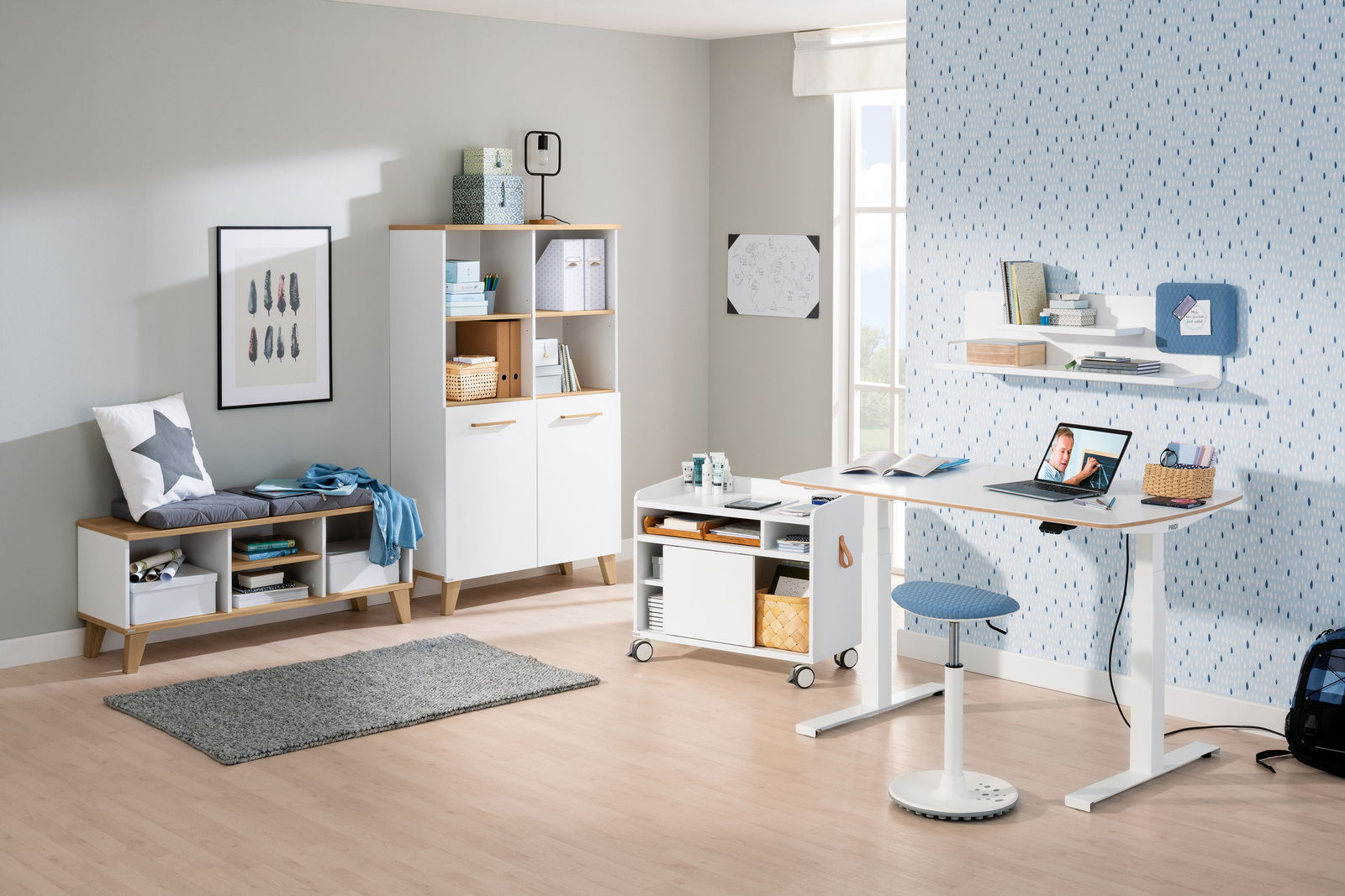 Moderner Schreibtisch in einem hellen Raum, mit einem Laptop und Büchern, seitliche Perspektive.