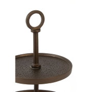 Detailansicht einer dunkelbraunen Metall-Etagere mit strukturierter Ablage und dekorativem Ringgriff, schräg von vorn und leicht von oben fotografiert