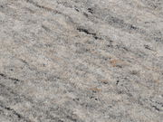 Nahaufnahme eines Wollteppichs mit grauen und beigen Farbtönen, von oben betrachtet.