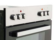 Nahaufnahme eines modernen Backofens mit silbernen Drehknöpfen und schwarzer Glastür, seitliche Perspektive