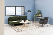 Grünes Funktionssofa in modernem Wohnzimmer mit blauer Wand, schwarzem Sessel und Beistelltisch, seitliche Perspektive.