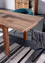 Esstisch aus Holz mit erweiterbarer Tischplatte, umgeben von gepolsterten Stühlen, aus der Vogelperspektive fotografiert.