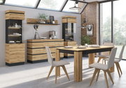 Moderne Esszimmermöbel aus Holz mit Esstisch, Sideboard und Vitrinen in einem hellen Raum mit großen Fenstern, seitliche Perspektive.