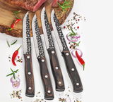 Vier Steakmesser HUNTER mit gehämmerten Klingen und Holzgriffen, von oben fotografiert, auf einem Schneidebrett mit Gewürzen und Chili.