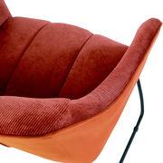 Nahaufnahme eines roten Armlehnstuhls mit weicher Polsterung und schwarzem Metallgestell, seitliche Perspektive