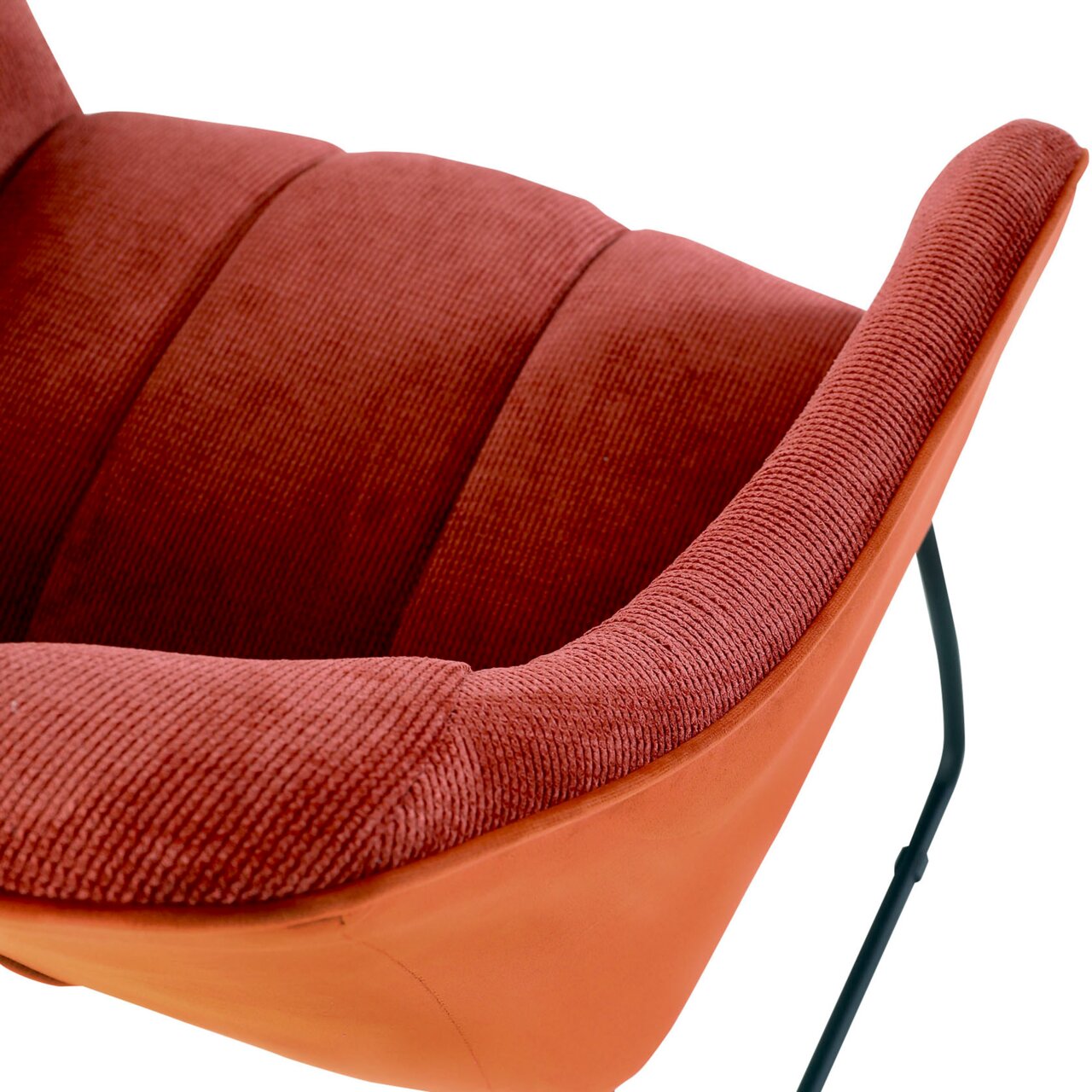 Novel Armlehnstuhl LAILA Nahaufnahme eines roten Armlehnstuhls mit weicher Polsterung und schwarzem Metallgestell, seitliche Perspektive