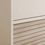 Nahaufnahme eines Kleiderschranks mit einer Kombination aus glatter und holzstrukturierter Oberfläche, seitliche Perspektive.