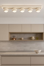 Moderne led-plafondlamp met vier ronde lampen, gezien van onderaf, gemonteerd in een stijlvolle keuken.