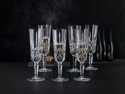 Zes elegante champagneglazen van kristal met een fijne slijpvorm, gevuld met champagne, tegen een zwarte achtergrond. Vooraanzicht.